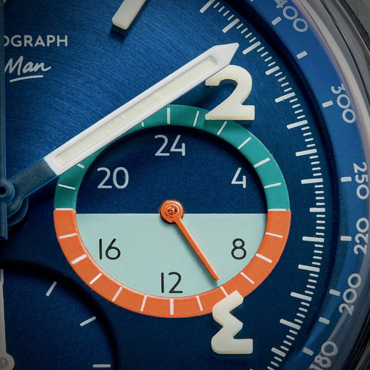 Macro of the brushed blue dial with the green, teal and orange subdial
